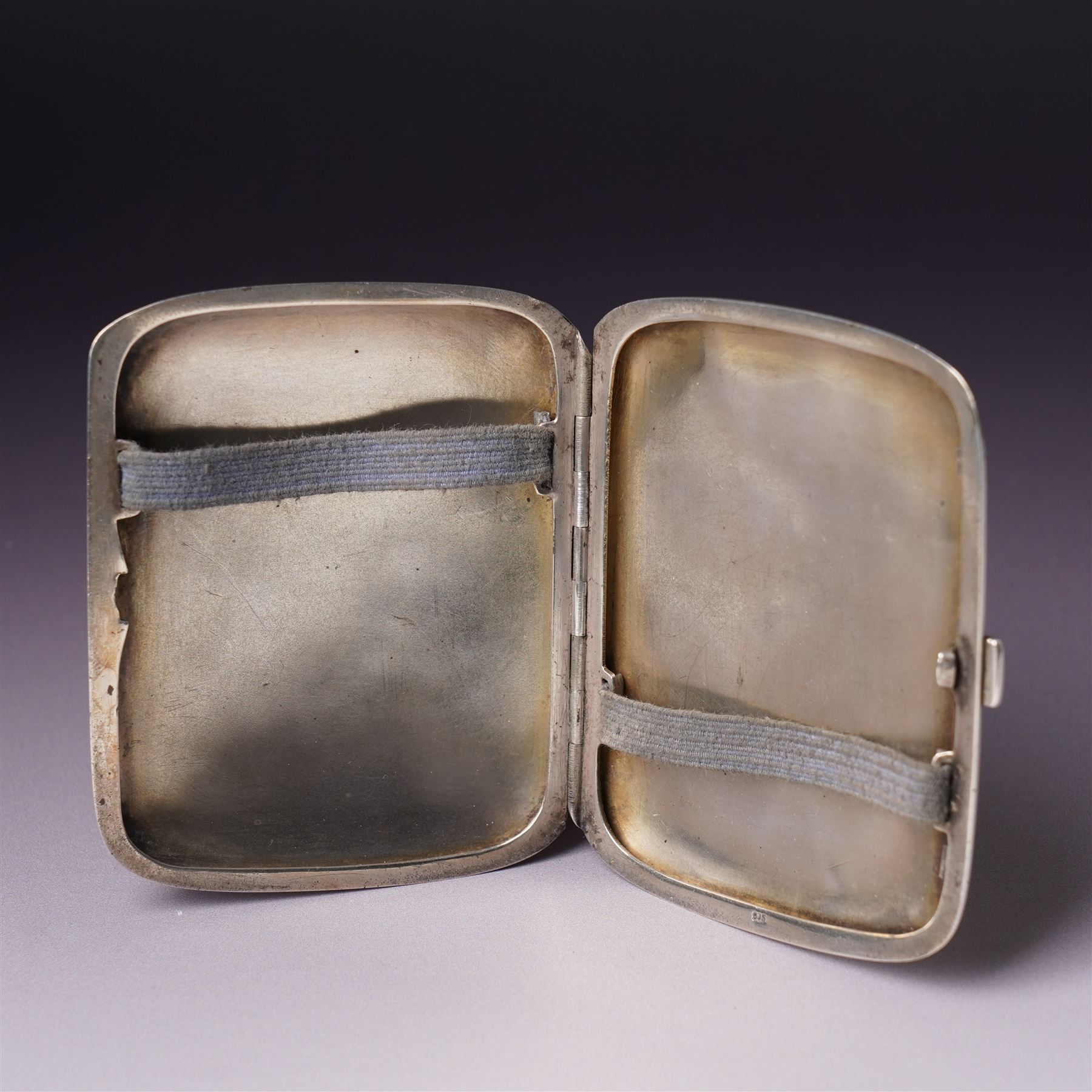 Early 20th century Continental silver and enamel cigarette case of rectangular cushion form, the front enamelled with a capercaillie in a Scottish woodland scene, marked 935, 9cm in length