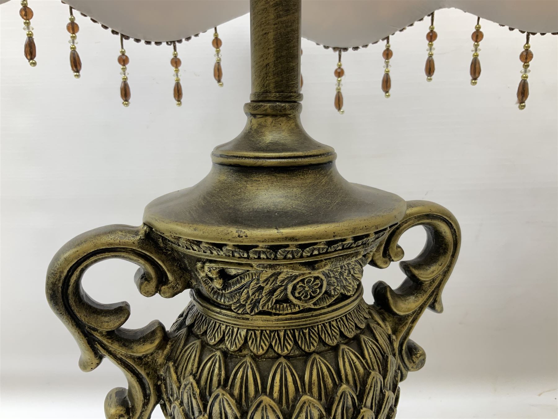Pair bronzed amphora lamps with pineapple decoration, scroll handles and foliate base with scrolled feet together with pair peach ground shades and raised floral pattern H76cm (2)