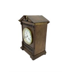 Edwardian - 19th century French 8-day walnut cased mantle clock, with a broken pediment and brass acorn finial, reeded pilasters and carving to the front on a moulded plinth, enamel dial within a brass bezel and flat glass, Roman numerals, minute markers and spade hands, rack striking movement , striking the hours and half hours on a coiled gong.