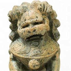 Pair of Chinese hardstone carved Foo dogs, each finely carved seated on rectangular plinth bases with detailed manes, collars and bells, the male with paw resting on a ball, the female with cub, in mottled green stone resembling jade
