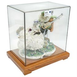 Unterweissbach style porcelain figural group of a seated lady with a gentleman playing a lute, stamped 'Foreign' to base, in bespoke display case
