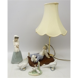  Nao figure of a girl holding puppy no. 1296, three Nao Geese and similar style Spanish lamp modelled as a boy sat with poodle on plinth base, H61cm   