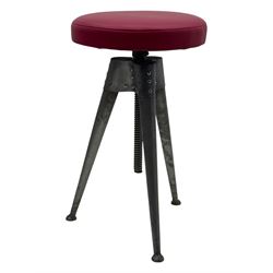 Contemporary industrial design riveted metal table, by repute fashioned from salvaged aeroplane parts, with a circular glass top on a tripod base, accompanied by three adjustable stools upholstered in burgundy