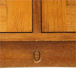 Acorn Industries - oak dresser base or sideboard, the rectangular top over three drawers with protruding oak handles, over four panelled cupboard doors enclosing a single shelf, raised on stepped feet, carved with acorn signature, by Alan Grainger, Brandsby