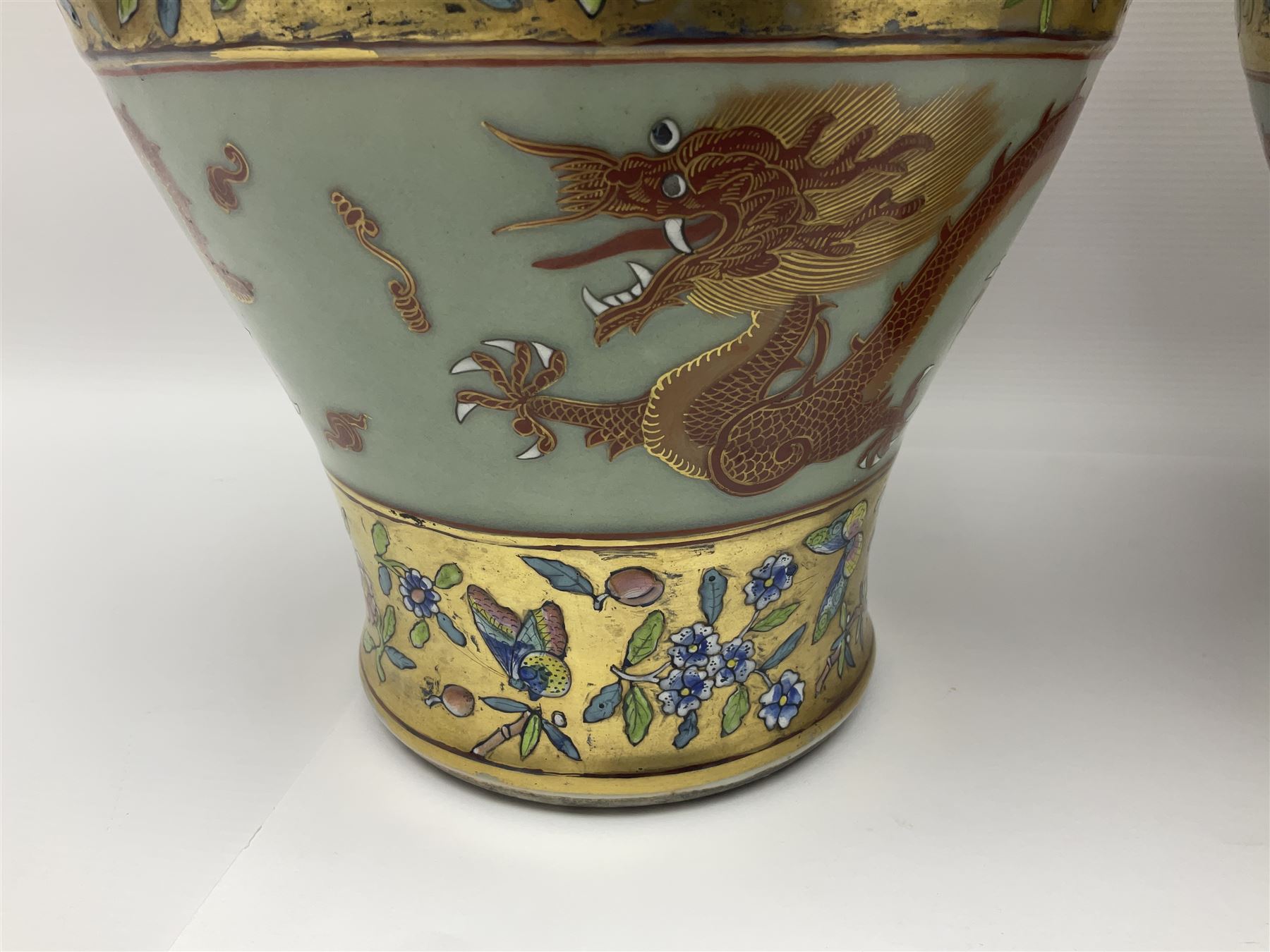 Pair of early 20th century Chinese vases decorated with dragons chasing a flaming pearl, with a gilt border of butterflies and floral sprigs, with Elephant head handles, H44cm 