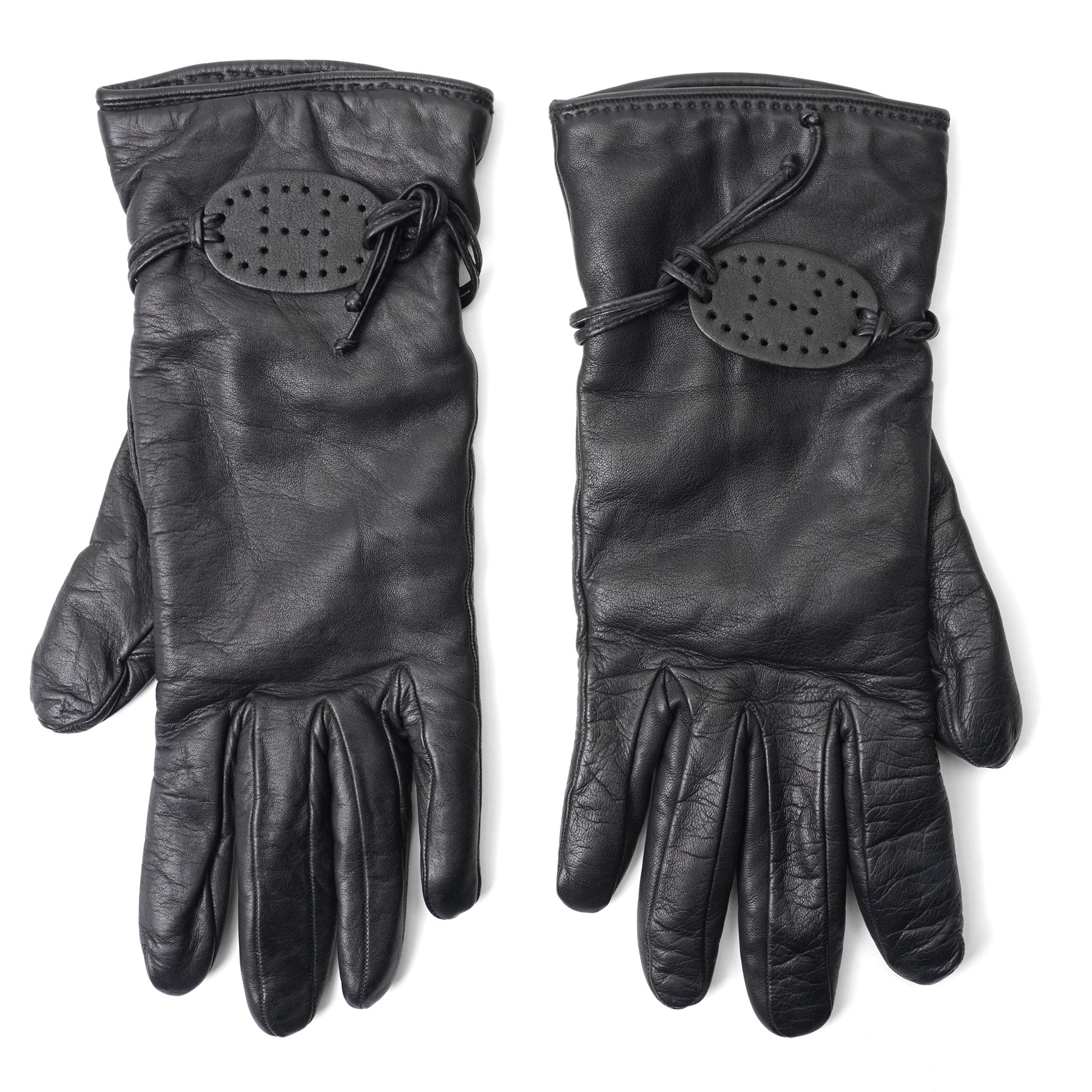 Hermès - pair of black leather gloves, lined in 100% cashmere, with pierced oval leather strap detail to cuffs, size 8