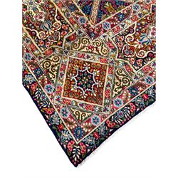 Persian Kirman indigo ground carpet, the field with repeating lozenge tiles with overall floral decoration, the main border with floral panels enclosed by the guards