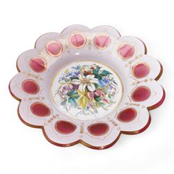 Early 20th century Bohemian cranberry glass flower form plate, overlaid with opaque and hand painted and gilded with a floral bouquet, D19.5cm, pair of cranberry glass pulpit vases, satin glass ewer and two further pieces of cranberry glass (6)