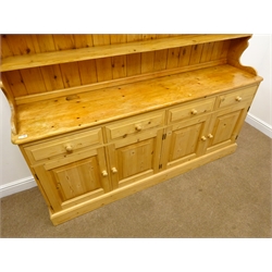  Large pine dresser, projecting cornice, three tier plate rack above four drawers and four fielded doors, platform base, W188cm, H198cm, D42cm  