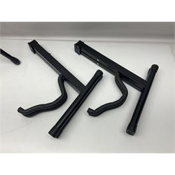 Four folding tubular guitar stands, two by RockJam; and folding tubular saxophone stand (5)