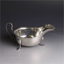 Three silver sauce boats, comprising pair of 1930s silver sauce boats, of typical form with shaped rim, scroll handle and upon three pad feet, hallmarked Viner's Ltd, Sheffield 1932 and a similar 1920s example with flying C scroll handle and upon three paw feet, hallmarked James Deakin & Sons, Sheffield 1923, tallest including handle H7.5cm
