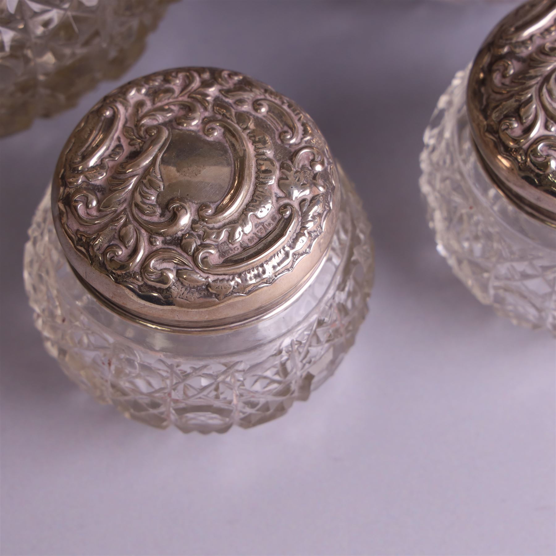 Early 20th century silver mounted cut glass scent bottle, with silver lid and three cut glass dressing table jars with silver lids, all hallmarked 