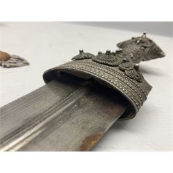 Omani Khanjar dagger, the 19cm curved blade with pronounced medial rib to either side, waisted hilt with dome shaped pommel and silver covered horn grip decorated with filigree bands, floral motifs and beadwork; in an intricately filigree decorated silver and leather scabbard with silver rings woven into the belt mount and fitted with original silver thread-work belt L34cm overall belt length 94cm