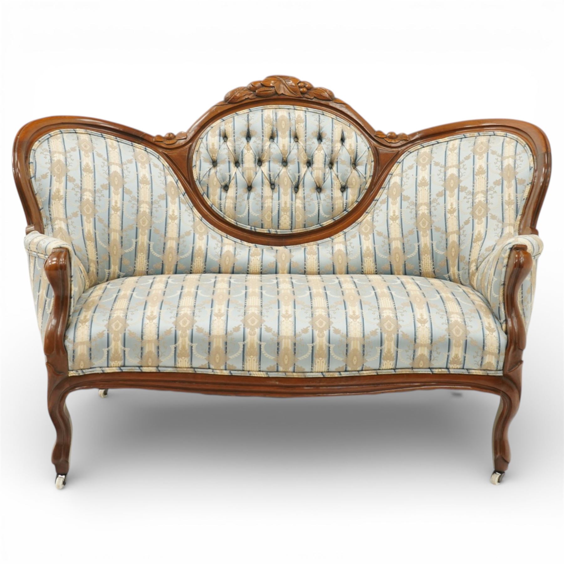 Victorian mahogany double cameo back sofa, the shaped back with central button upholstered oval panel and carved foliate crest above upholstered arms and seat, raised on cabriole legs terminating in castors