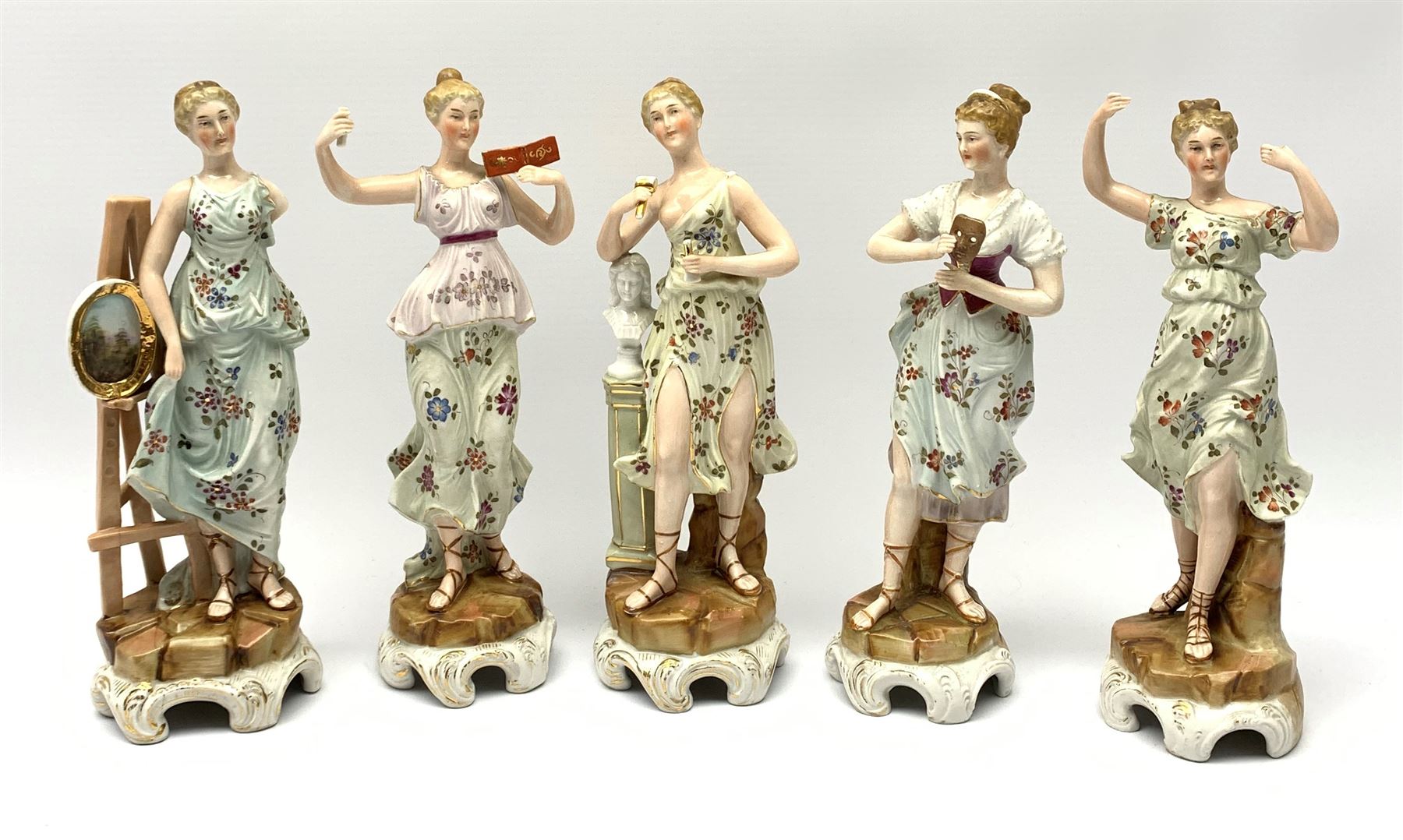 A group of five Continental figurines modelled as the arts, emblematic of music, painting, sculpture, literature, and theatre, each with spurious blue cross mark beneath, H22.5cm. (5). 
