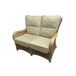 Contemporary rattan conservatory suite - two seat sofa with wicker frame and loose cushions upholstered in textured champagne fabric (W125cm H98cm); pair of matching armchairs (W72cm H98cm); rectangular glass-topped coffee table with rattan frame and undertier (W85cm D60cm H47cm); and matching square side table (W53cm H55cm)