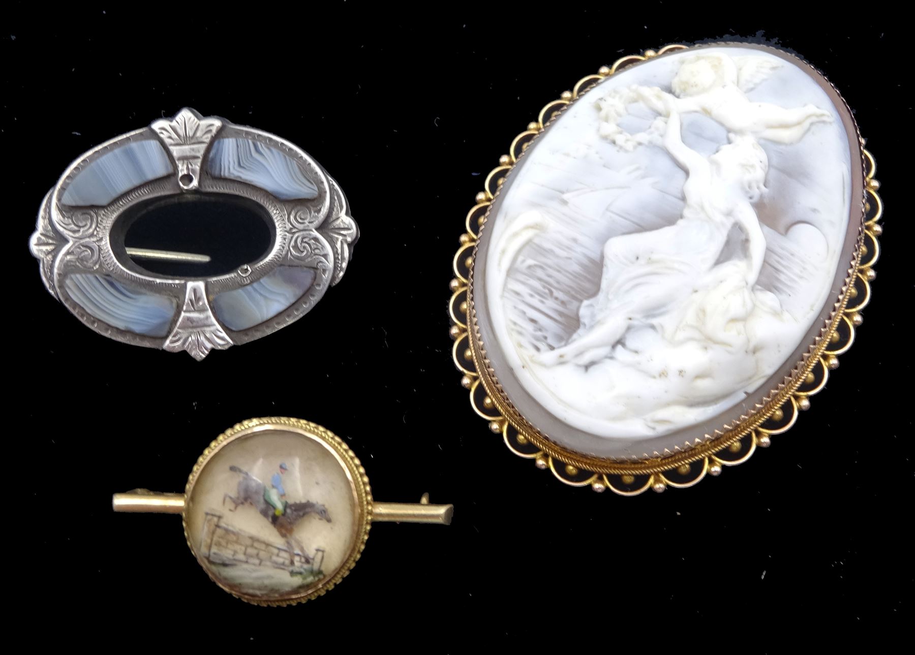 Early 20th century rose gold cameo brooch depicting a goddess by the sea possibly Amphitrite, stamped 9ct makers mark H & N (possibly Hollis & Newman), the back inscribed 'Ted to .. and dated 1912', early 20th century gold Essex crystal jump jockey brooch and Victorian silver blue agate brooch