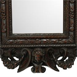 Renaissance-style mid 19th century carved fruitwood wall mirror, carved top surmounted by ‘broken’ arched pediment with central putti figure and grape vine, the sides with two putti figures above C-scroll decorations, and with a similarly carved base