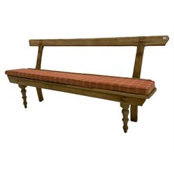 19th century rustic stripped pine bench, raised back rest over plank seat with squab cushion, turned supports