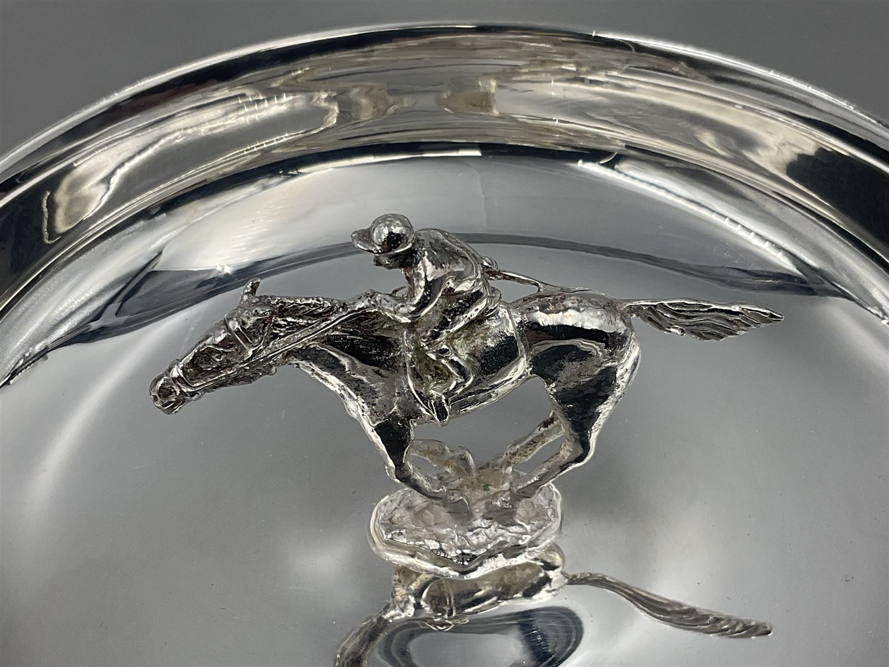 Spanish silver coin dish, with white metal chain rim and upon three ball feet, together with a silver plated armada style dish, with cast racehorse and jockey to centre, coin dish D4.8cm, armada dish D20.5cm
