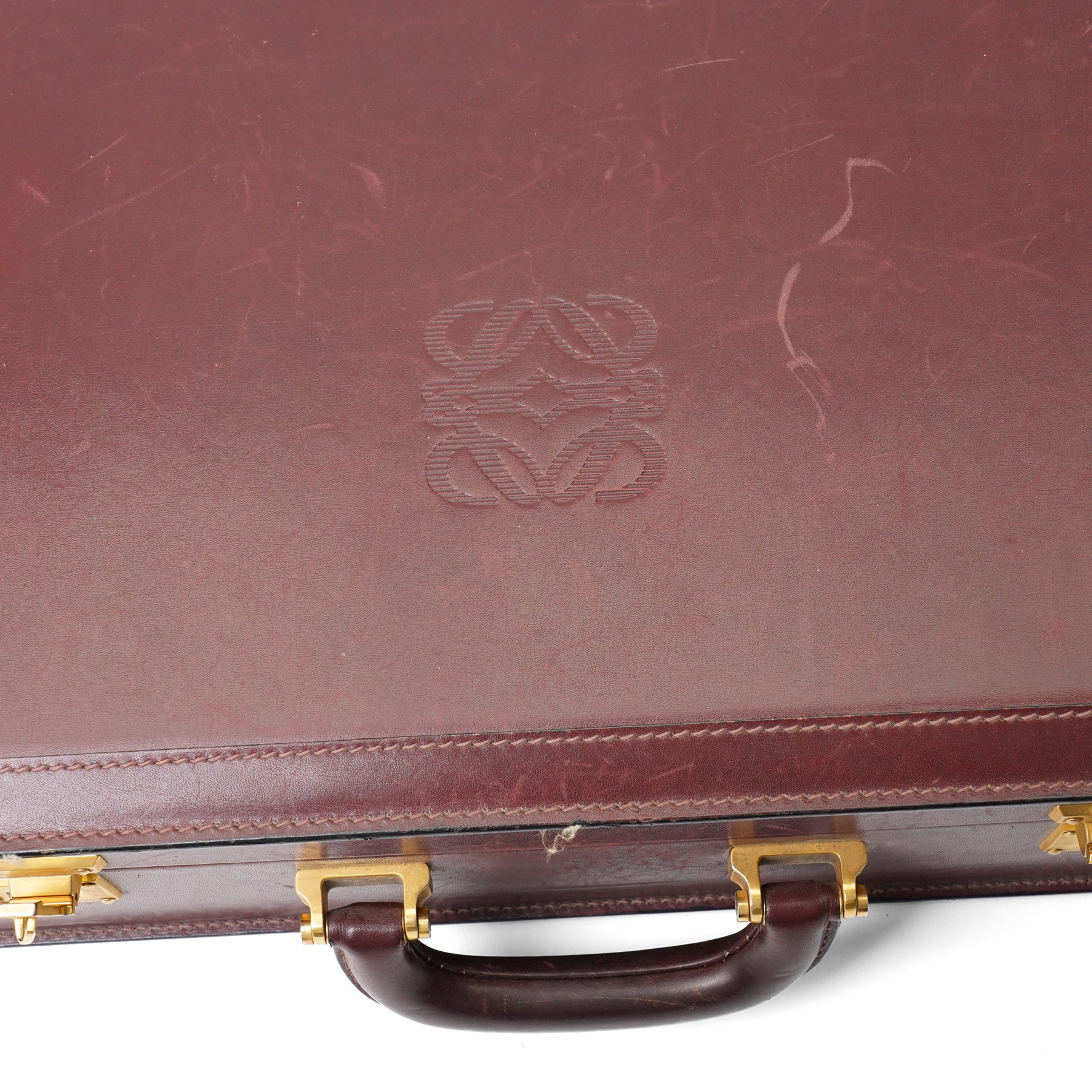 Loewe - vintage burgundy leather attaché case, the exterior embossed with Loewe Anagram, with gilt-tone hardware, twin combination locks and leather handle, opening to a suede-lined fitted interior with document compartments, pen loops and pockets, stamped LOEWE Madrid 1846