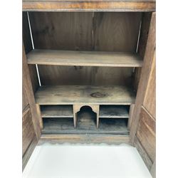20th century oak spice cupboard, two twin fielded panel doors enclosing pigeon holes and series of shelves, on shaped apron and bracket feet
