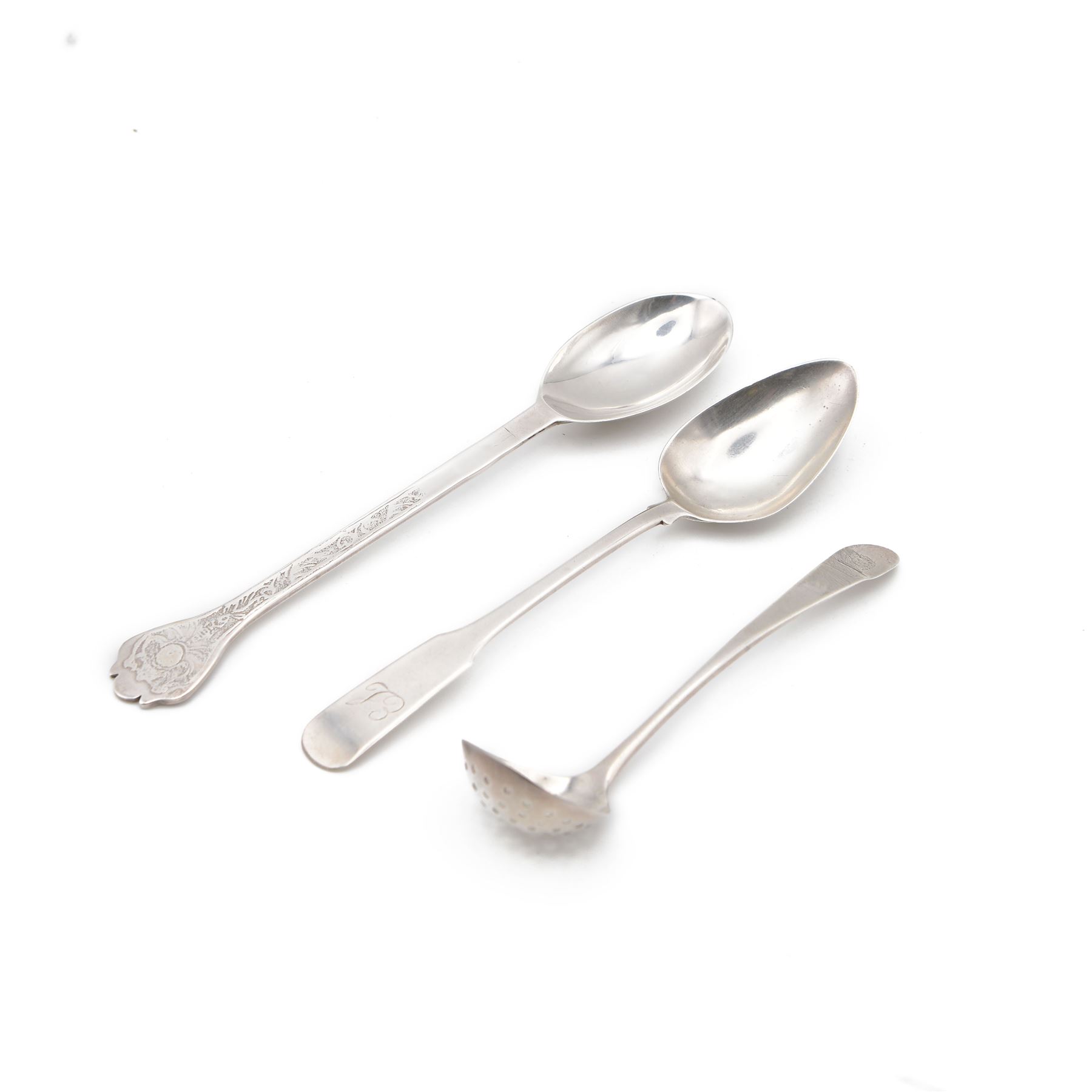 Late 20th century Scottish silver Arts and Crafts style trifid teaspoon with oval rattail bowl, with chased decoration to stem, hallmarked Isle of Mull Silver Co, Edinburgh 1986, together with two Scottish provincial silver spoons, comprising spice lifter, hallmarked William and Patrick Cunningham, Edinburgh and a Fiddle pattern teaspoon, hallmarked William Hannay, Paisley, C1837, both with engraved crests/initials