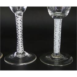 Four 18th century wine glasses, the funnel bowls upon double series opaque twist stems and conical feet, tallest H15.5cm