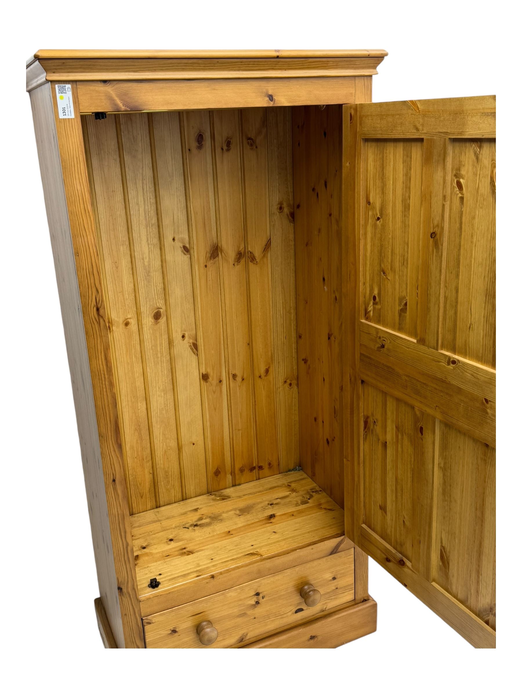 Pine single wardrobe, enclosed by single panelled door, fitted with single drawer, on plinth base 
