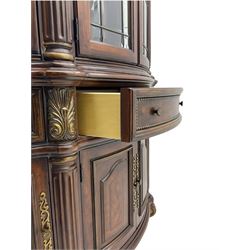  Kevin Charles American walnut demi lune display cabinet with illuminated interior, projecting cornice, two bevel edge glazed doors enclosing two adjustable shelves above single drawer and four cupboard doors with wine rack, carved scrolling supports