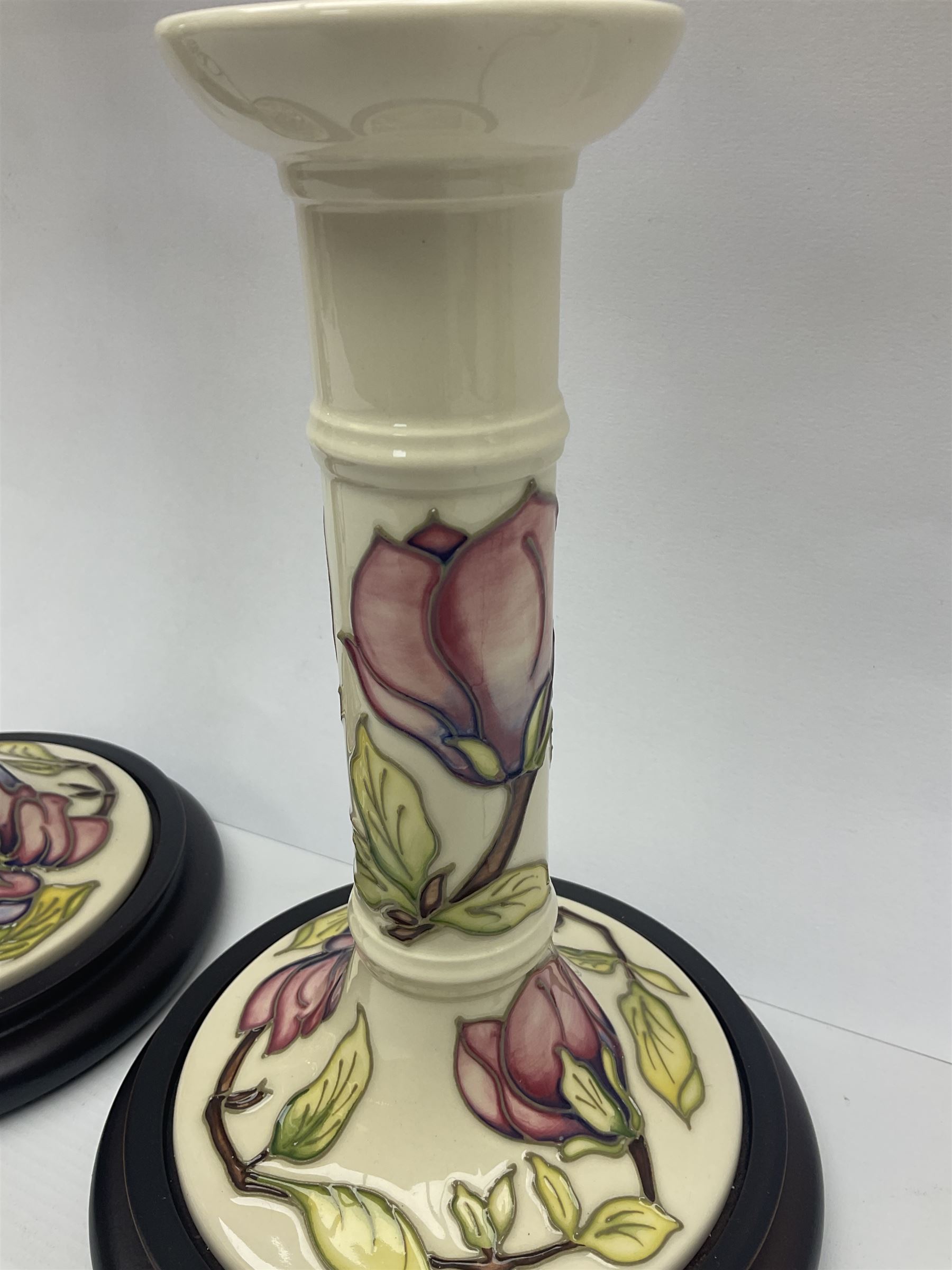 Pair of Moorcroft table lamps of candlestick form in magnolia pattern, with Moorcroft shades, H50cm 
