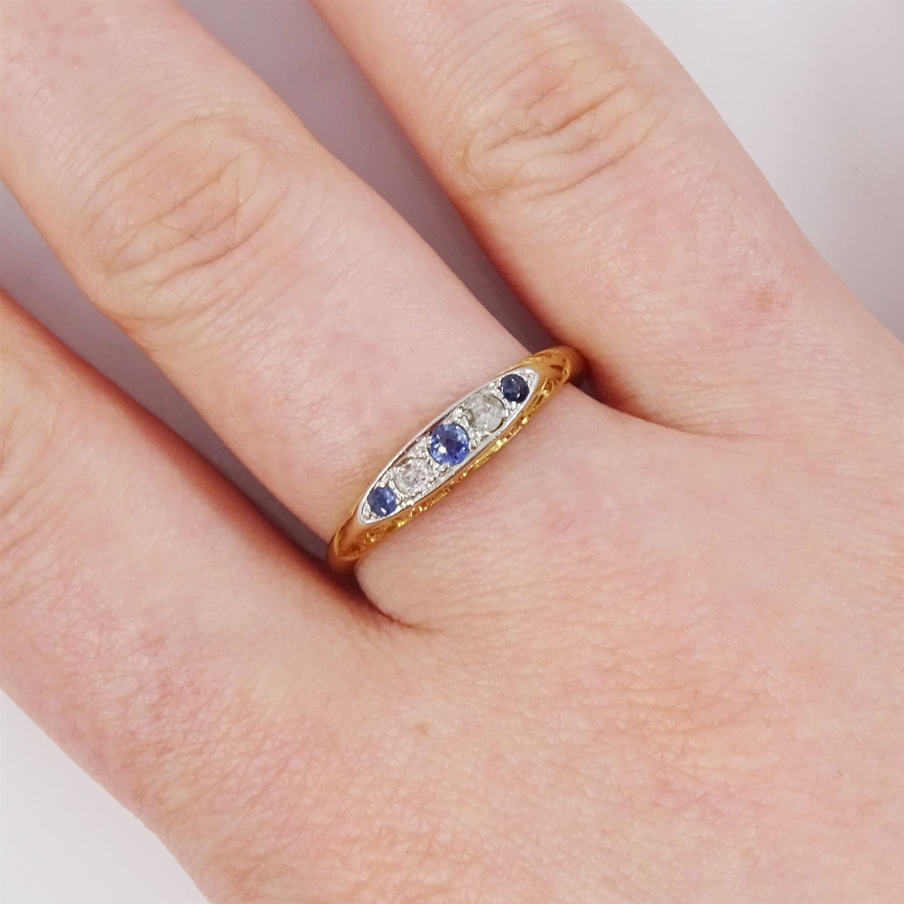 Early 20th century 18ct gold sapphire and diamond five stone ring, set with three round cut sapphires and two old cut diamonds and scroll engraved gallery 