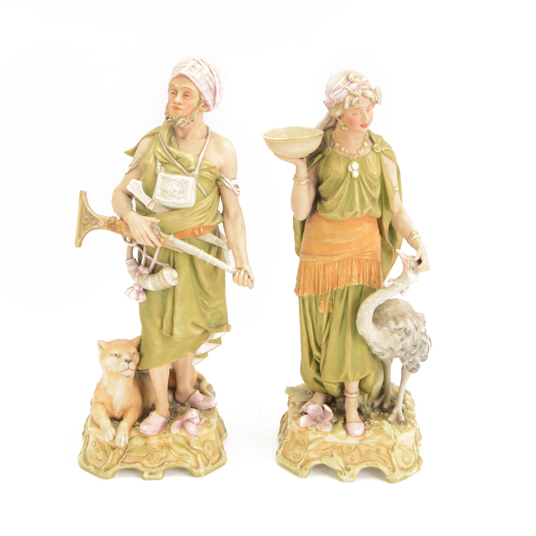 Pair of Royal Dux spill vase figures, modelled as a huntsman and water carriers, each with exotic animals to the base, H45cm