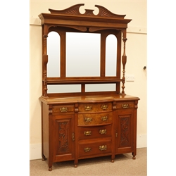 Edwardian walnut sideboard, shaped and carved pediment, two turned and fluted columns, three piece bevel edged mirror back, ogee fronted shelf above two mirrors, break bow front, six drawers, flanked by two floral carved panel doors, turned supports, W138cm, H227cm, D54cm  