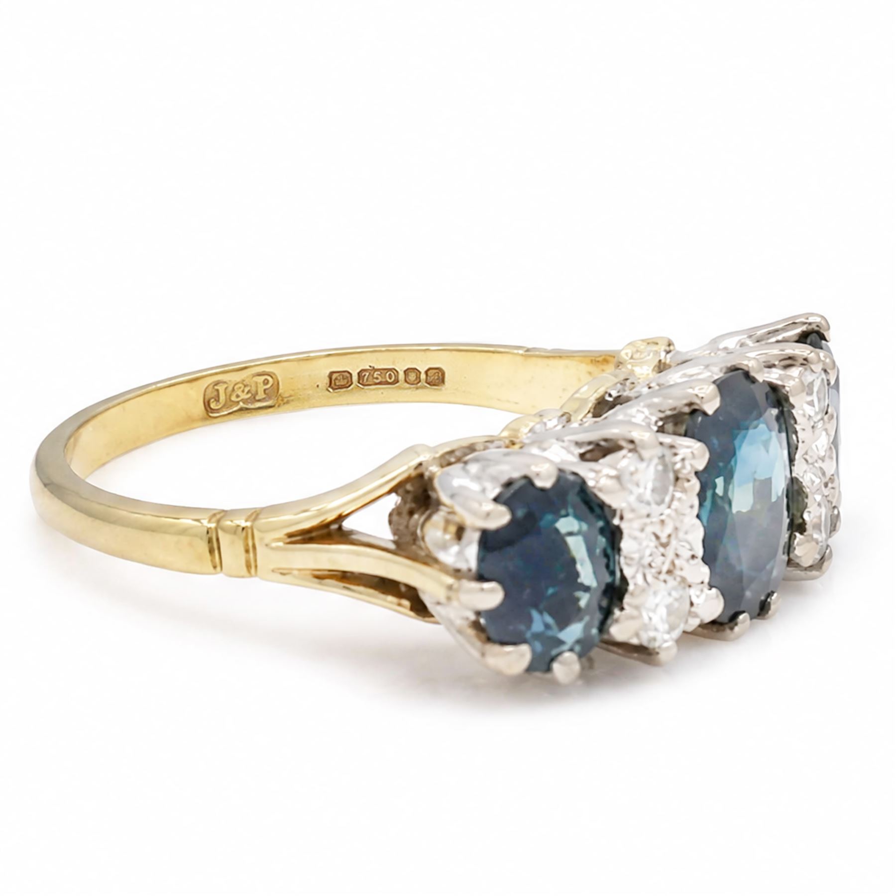 18ct gold sapphire and diamond ring, three graduating oval cut sapphires, the principal stone with two round brilliant cut diamonds set either side, London 1975, total sapphire weight approx 2.70 carat