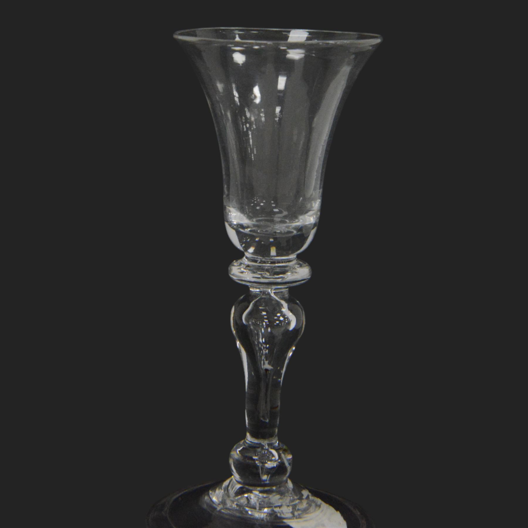 Mid 18th century wine glass, circa 1730-1740, with bell shaped bowl upon an inverted baluster stem with internal tear and basal knop, upon conical folded foot, H15cm
