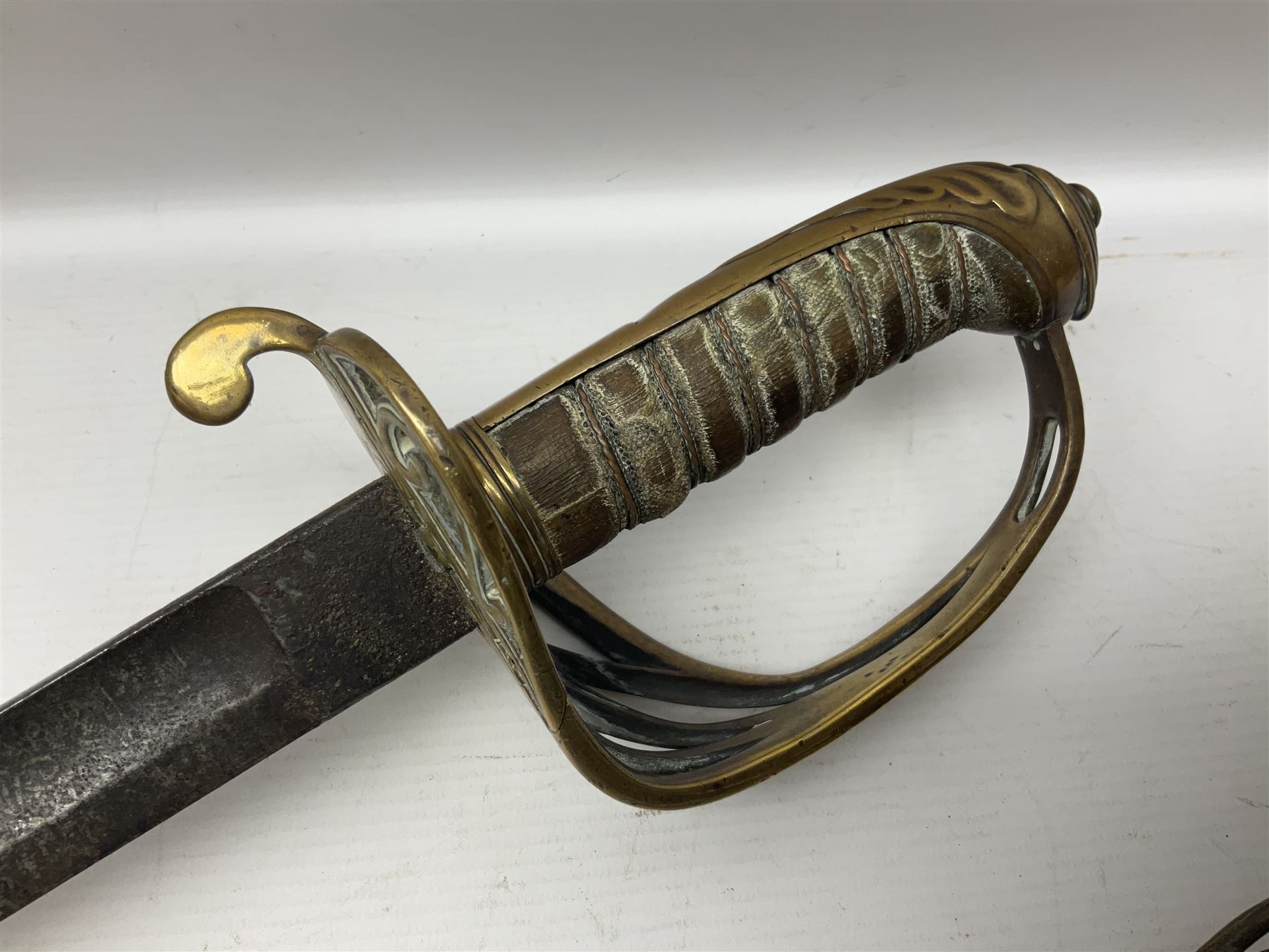 Victorian 1845 pattern infantry officer's sword the 82cm sharpened fullered steel blade with traces of decoration, brass gothic hilt incorporating Victorian cypher, folding back guard, stepped pommel with acanthus leaf backstrap and wire-bound wooden grip with traces of original fish skin covering L96cm overall; together with a reproduction Scottish style basket hilted sword; both lacking scabbard (2)