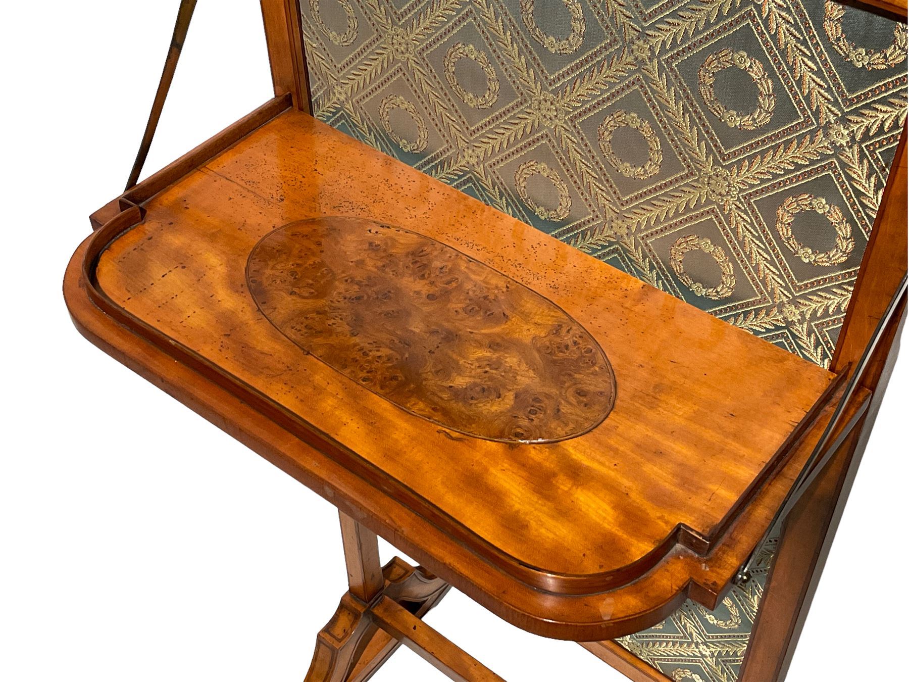 Late George III satinwood fire screen, upholstered in floral blue fabric, fold-down lipped tray with central figured walnut oval inlay, on splayed supports joined by stretchers 