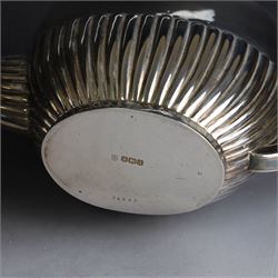 1920s silver three piece tea service, comprising teapot, twin handled open sucrier and milk jug, each of oval part fluted form, the teapot with Bakelite type handle and finial, hallmarked Cooper Brothers & Sons Ltd, Sheffield 1922