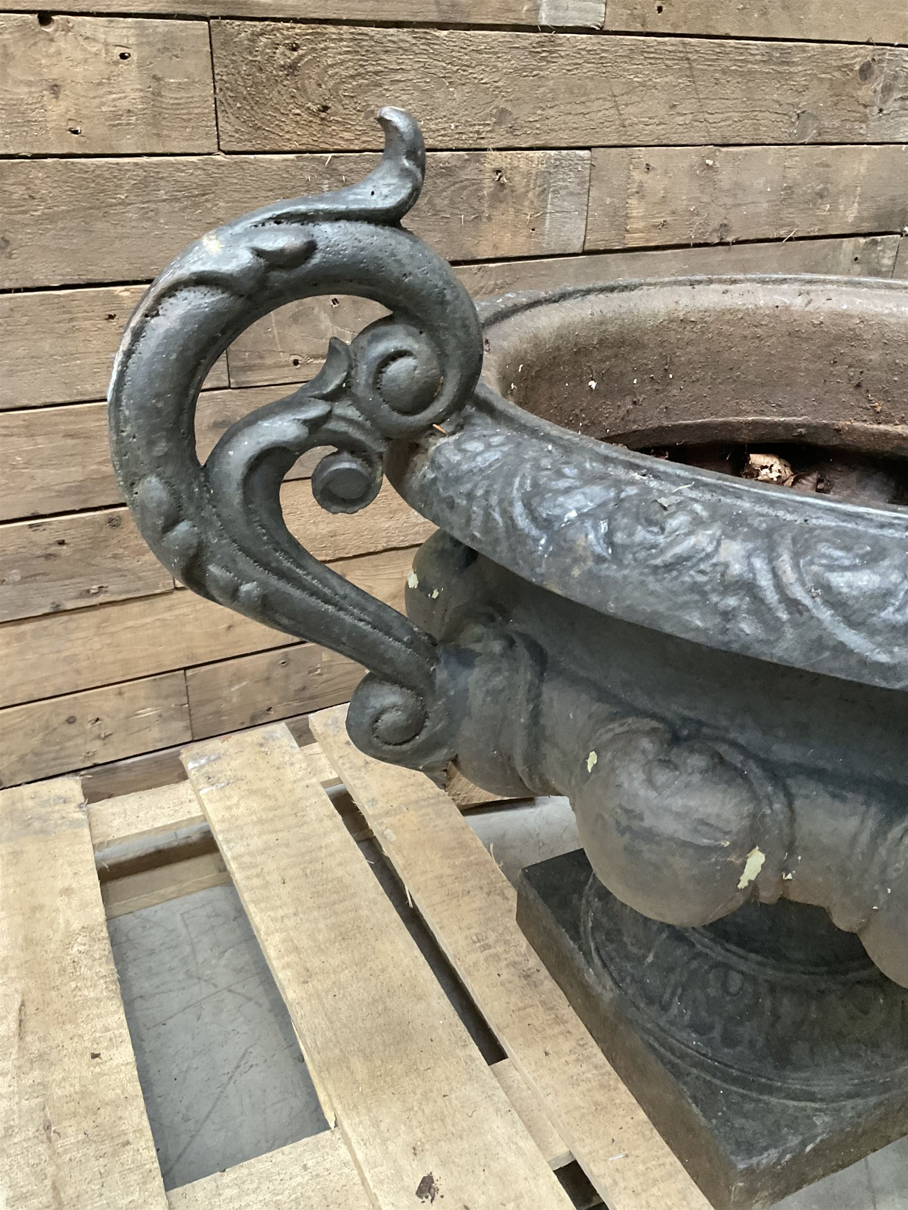 Victorian design ornate cast iron centrepiece urn, featuring two handles, raised on footed base