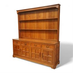Seahorseman by Shaw & Riley - Yorkshire oak Welsh dresser, the dresser rack of rectilinear form with plain frieze and projecting moulded edge above two shelves with central shallow groove, the base section fitted with four drawers and a fitted cutlery drawer containing cutlery, above four panelled cupboard doors with geometric mouldings and carved sculpted handles, interior with single shelf and sides with geometric mouldings raised on a shallow plinth base with shaped bracket feet, with signature Seahorse carving from the workshop from the workshop of A. Shaw & Riley Ltd, Hessay