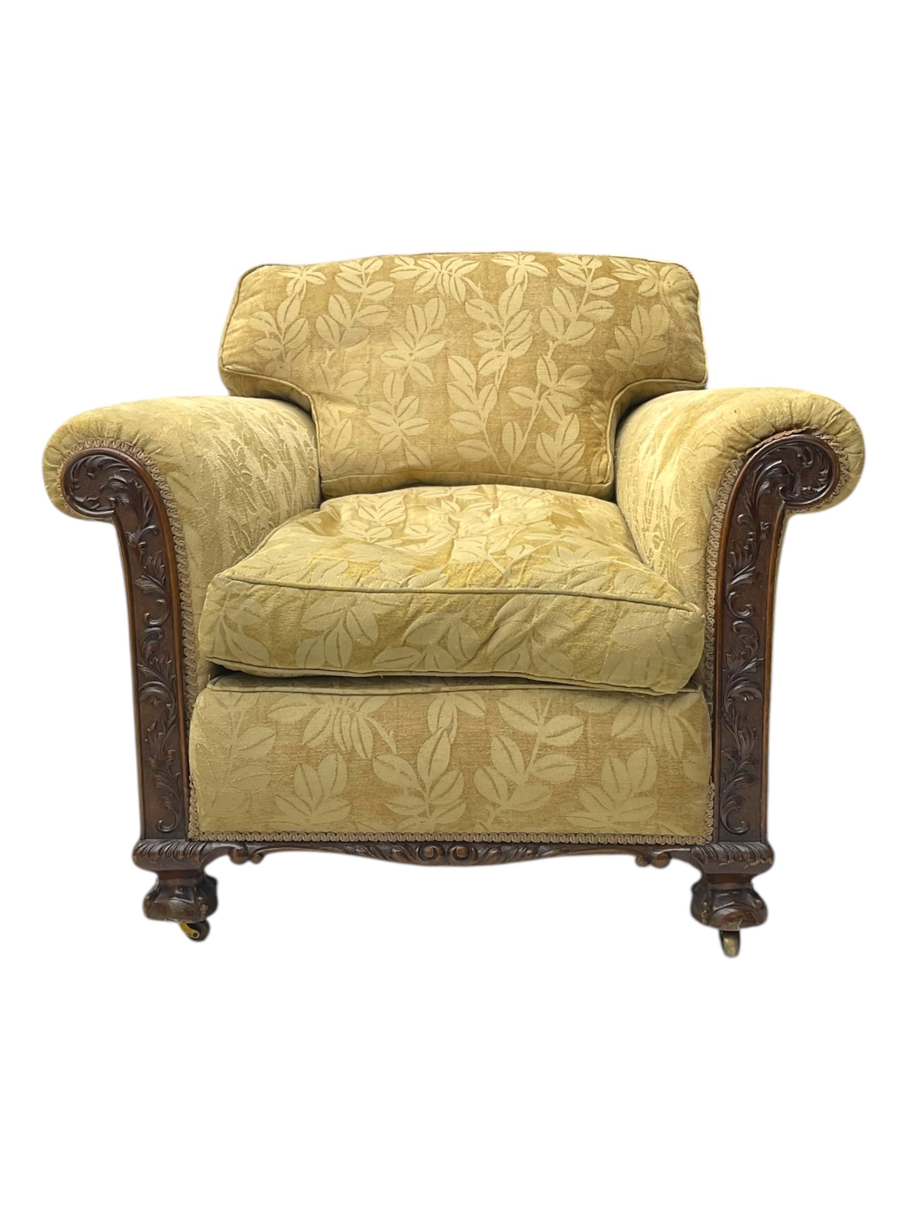 Early 20th century mahogany framed three-piece lounge suite - three-seat camelback sofa (W203cm, D105cm); pair of matching armchairs (W95cm, D96cm); upholstered in neutral foliate pattern fabric, carved with trailing leafy branches, ball and claw carved feet with brass castors 