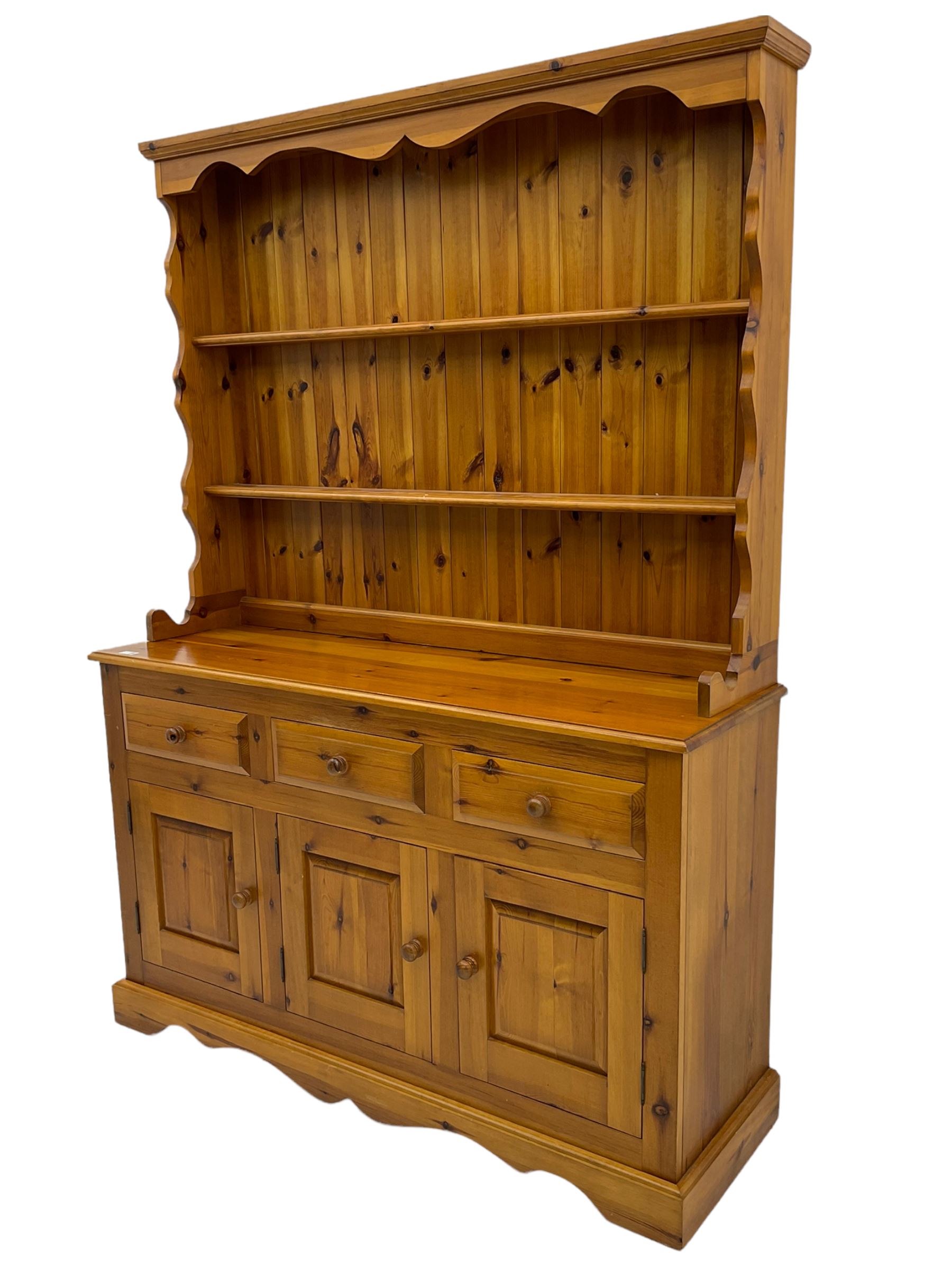 Pine farmhouse dresser with three drawers and three cupboards, and two tier plate rack