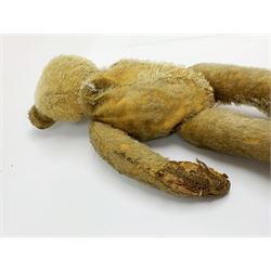 Early 20th century American mohair teddy bear c1920 with wood wool filled body humped back body with jointed limbs, black boot button eyes and horizontal stitched nose and mouth H12