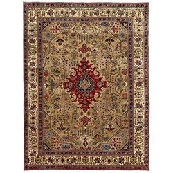 Persian Azarbaijan golden ground carpet, the shaped crimson ground medallion decorated with geometric motifs, the field profusely decorated with stylised plant and flower head motifs, repeating border with guard bands 