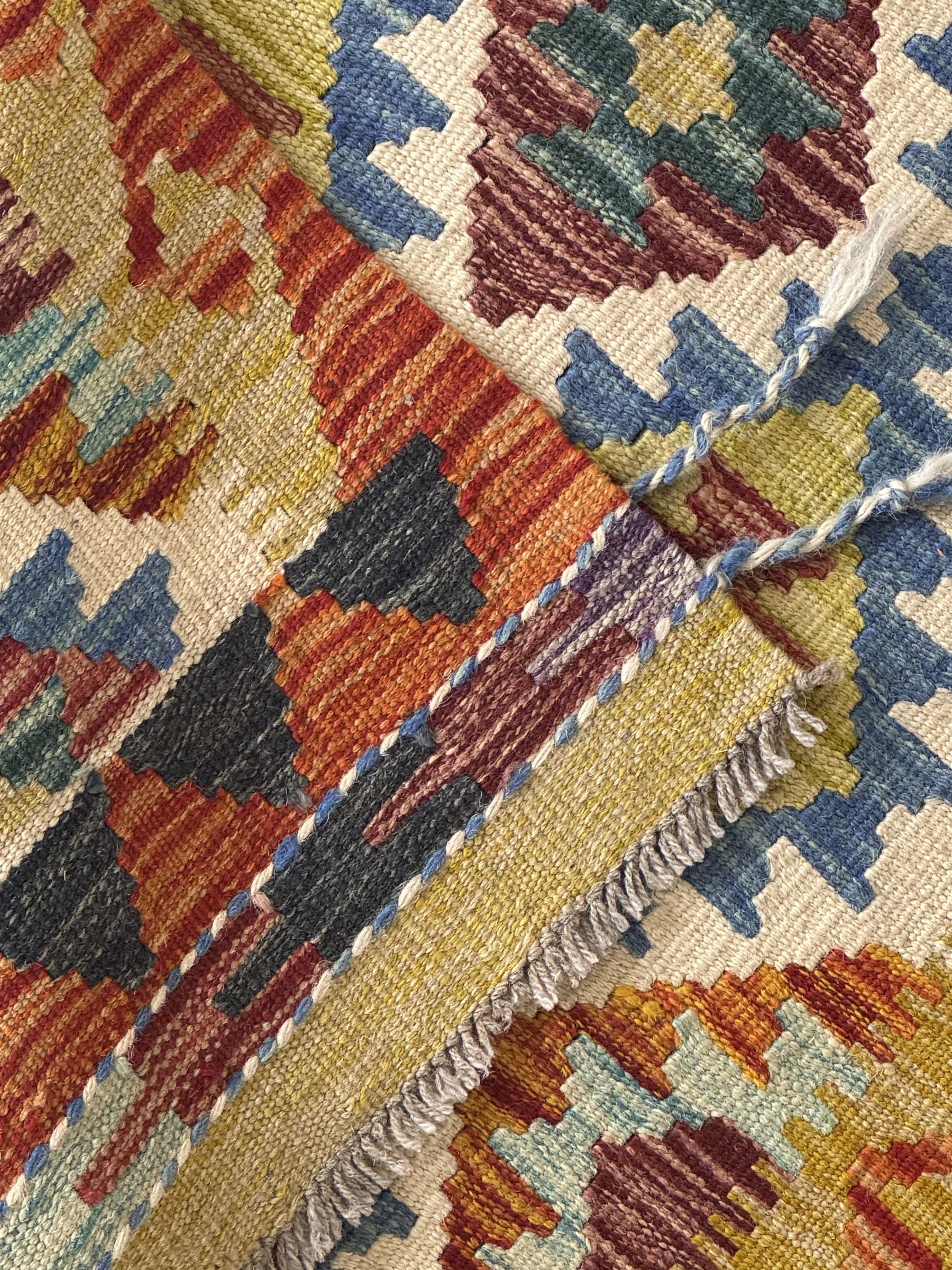 Chobi Kilim runner, cream ground with a multicoloured lattice of repeating diamond motifs, framed by a geometric border, finished with braided corner tassels