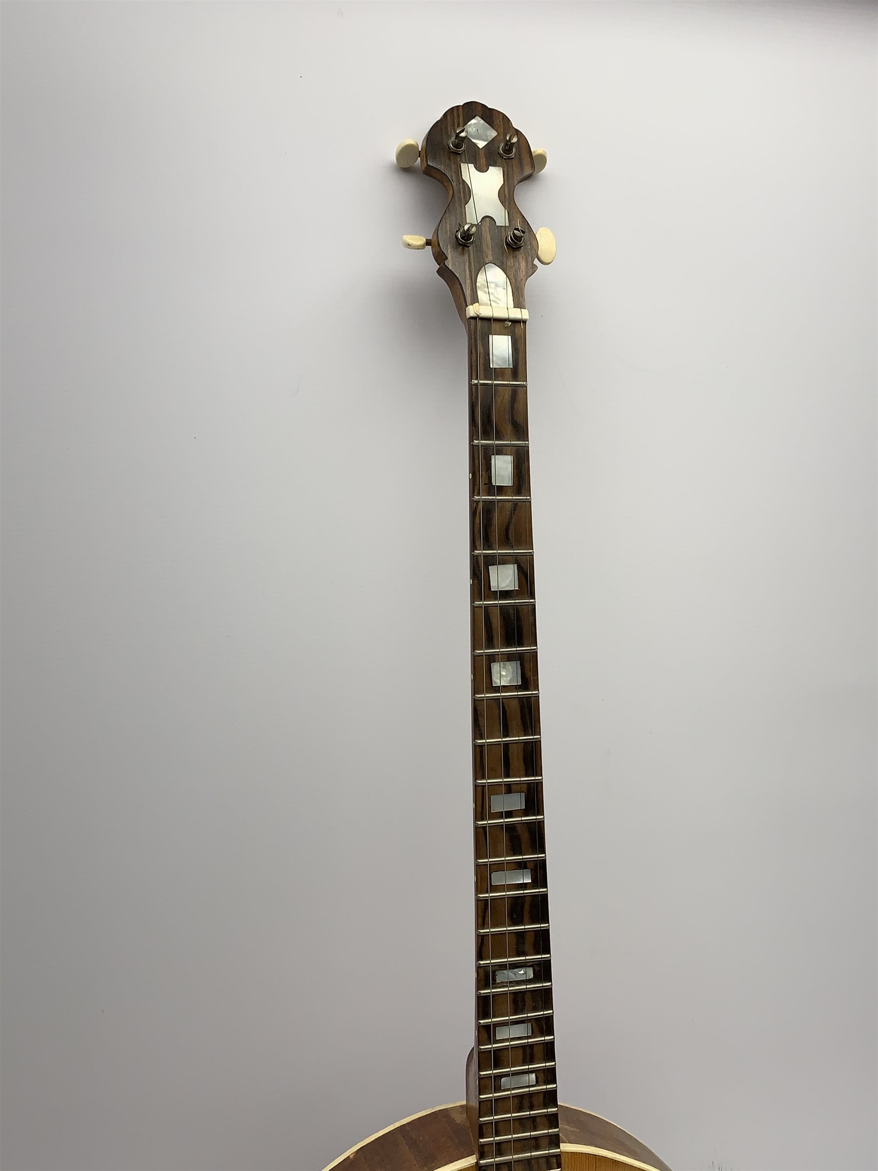Four-string banjo guitar with mahogany circular back and sides and spruce top, mother-of-pearl inlaid fingerboard and headstock, bears humorous label 'Fender Bedpanjo', L95cm