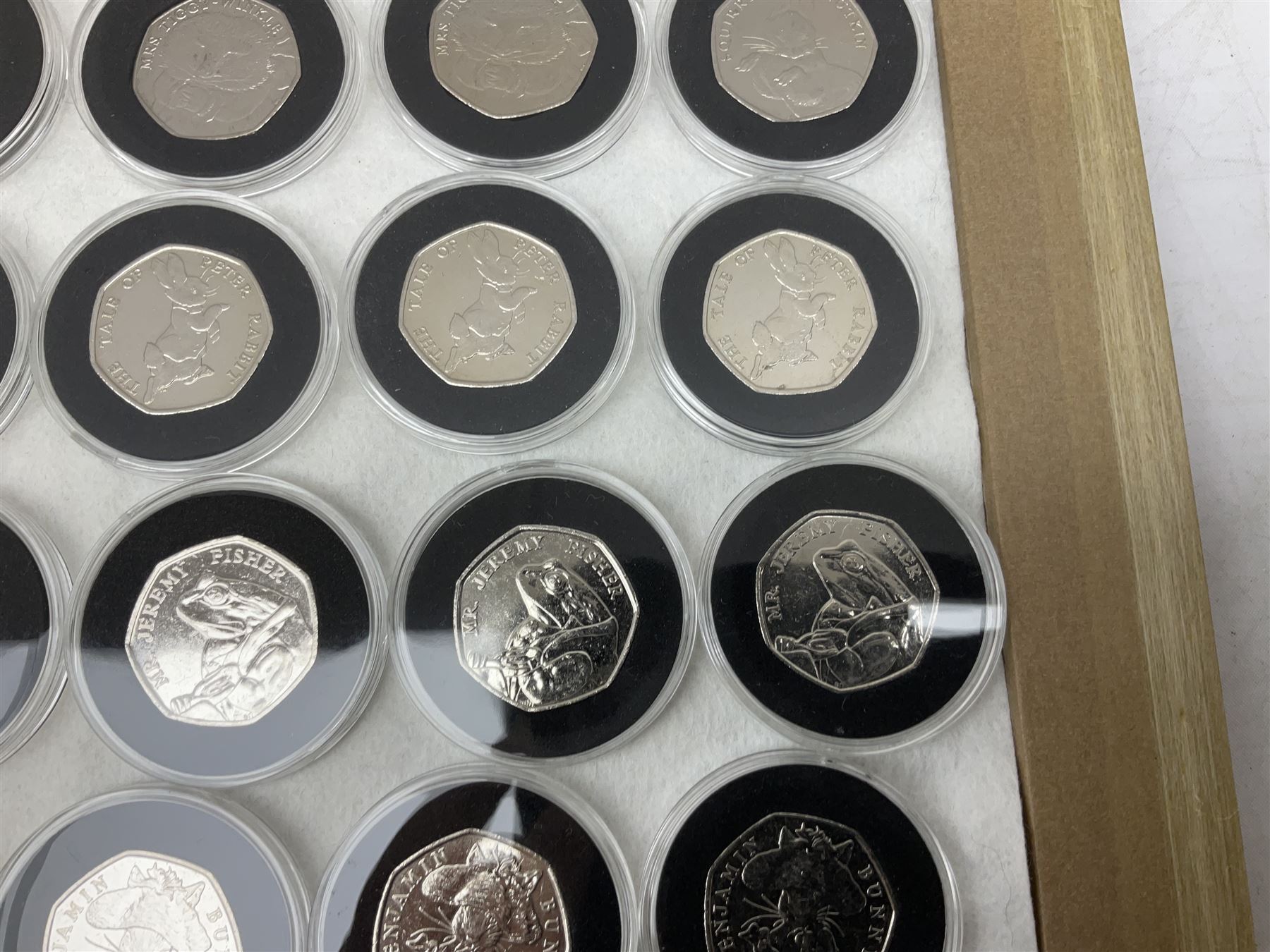 Thirty-seven commemorative fifty pence coins, including 2011 wrestling, other Olympics, Beatrix Potter etc, housed in capsules