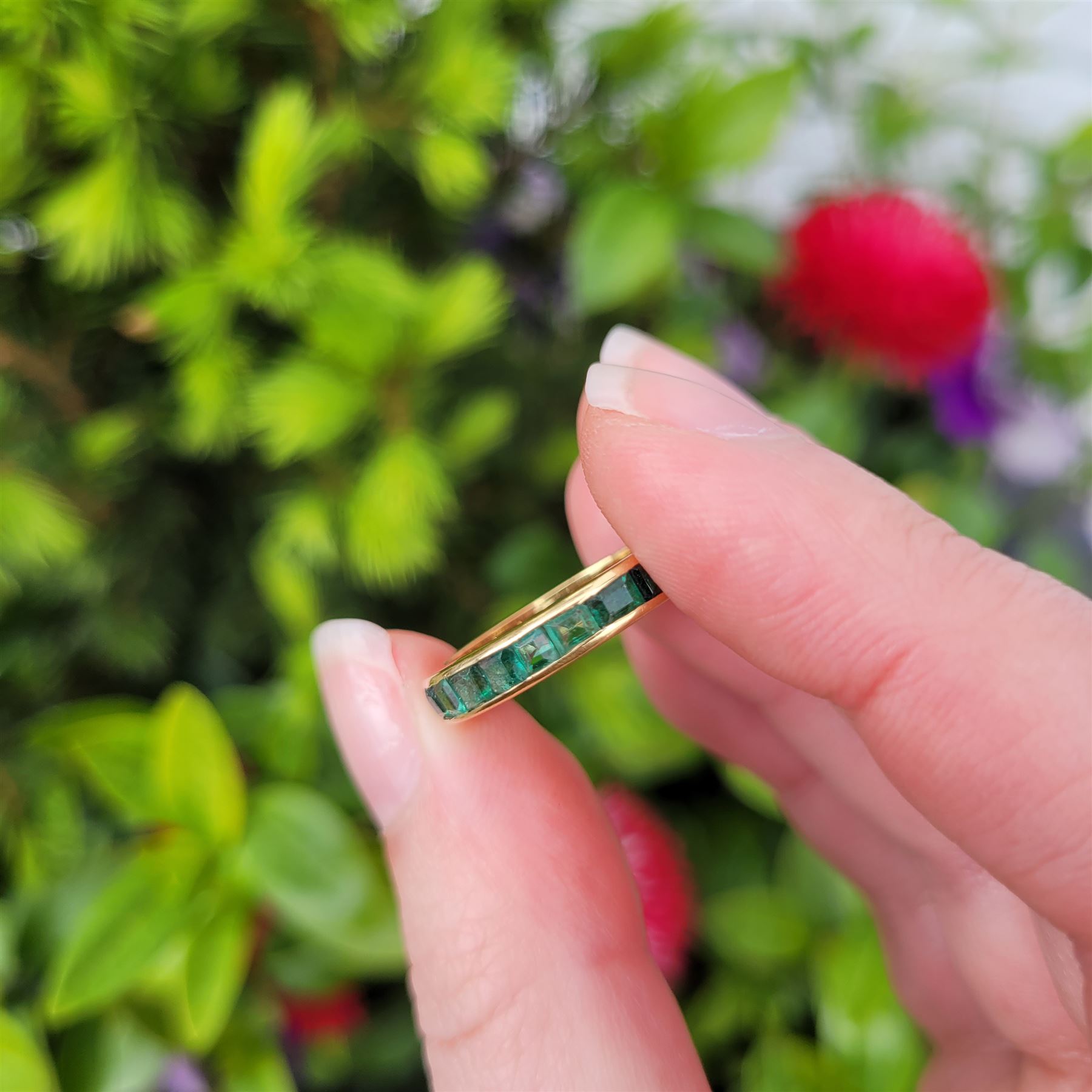 18ct gold emerald full eternity ring, channel set with calibre cut emeralds