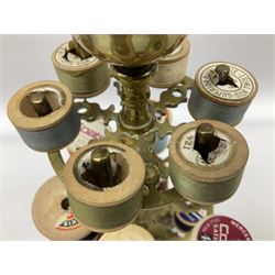 Victorian brass bobbin holder, with three tiers and pin cushion terminal, upon a foliate cast base with four paw feet, H29.5cm, together with a Victorian inlaid box, the holder supporting and box containing a number of cotton reels, (2)
